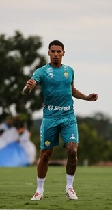 Volante Denílson do Cuiabá durante treino no CT Manoel Dresch, focado na preparação para enfrentar o CRB pela Série B 2024. Imagem mostra o jogador com a bola, evidenciando o trabalho técnico-tático da equipe.