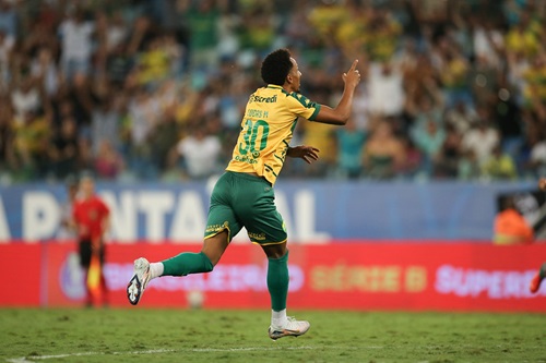 Lucas Mineiro., celebra um gol correndo em direção à torcida, apontando para o alto com o dedo indicador.