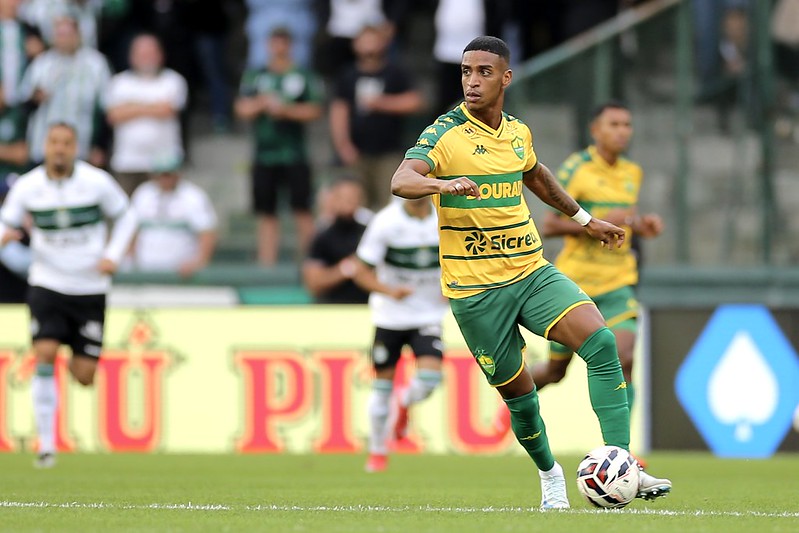 Max (Cuiabá) dribla a bola em jogo contra o Coritiba, vestindo a camisa amarela e verde.