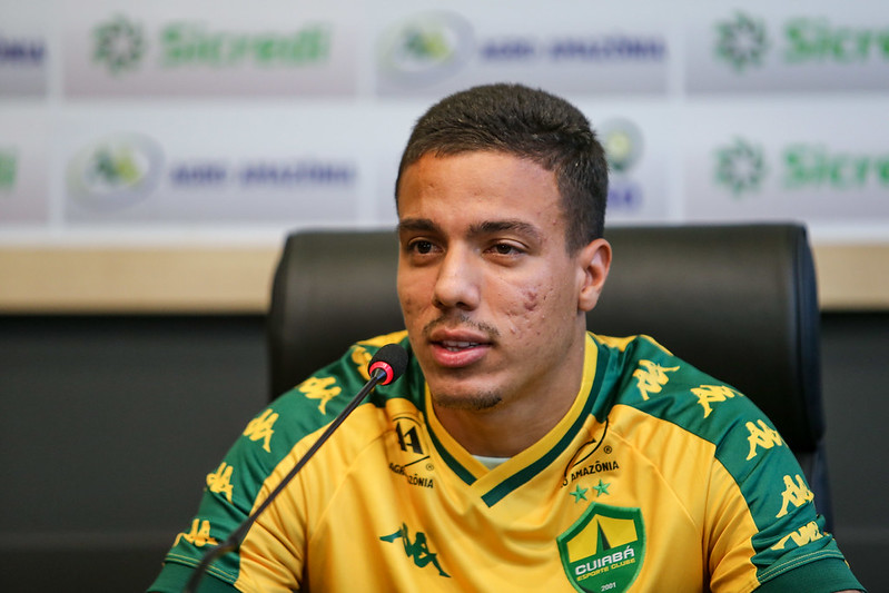 Carlos alberto em coletiva respondendo aos reporteres com a camisa do cuiaba amarela