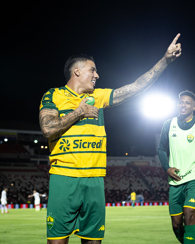 carlos alberto comemorando gol com os braços erguido e com a camisa do cuiaba amarela
