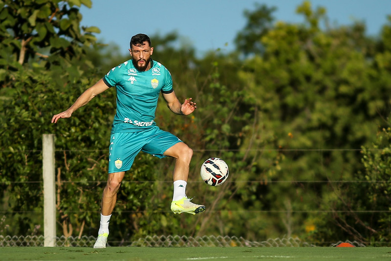 Lateral Sander em ação, tocando na bola durante o treino, vestindo o uniforme verde-água.