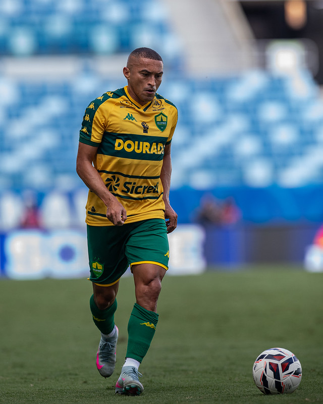 O lateral Nino Paraíba em campo, usando o uniforme do Cuiabá, com uma bola de futebol aos seus pés.
