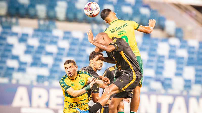 Jogadores de Cuiabá e Sport Sinop disputam bola pelo alto durante partida do Campeonato Mato-Grossense na Arena Pantanal.
