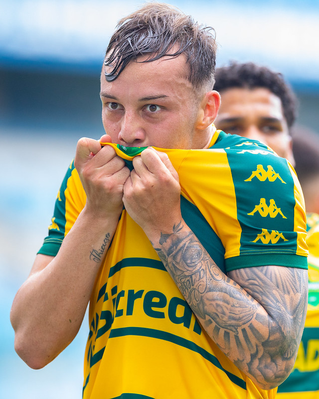 Luiz Felipe beija o escudo do Cuiabá após a partida na Arena Pantanal, celebrando a vitória no Campeonato Mato-grossense diante da torcida.