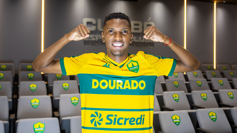 Vinícius Peixoto posa com a camisa do Cuiabá EC no auditório do clube durante sua apresentação oficial como reforço.