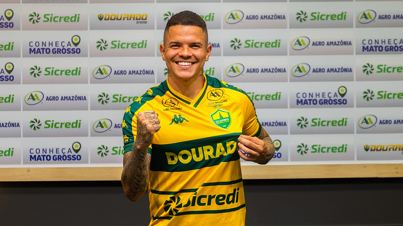 Rodrigo Rodrigues segura a camisa do Cuiabá EC durante sua apresentação oficial como novo atacante do Dourado.