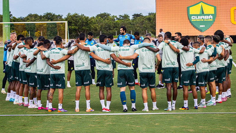 Jogadores do Cuiabá Esporte Clube reunidos em círculo durante treino, demonstrando união e preparação para estreia na Copa Centro-Oeste