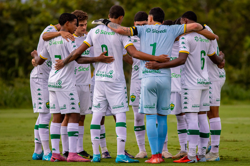 Jogadores do Cuiabá Sub-20 reunidos em roda antes da partida, mostrando união e espírito de equipe no CT Manoel Dresch.