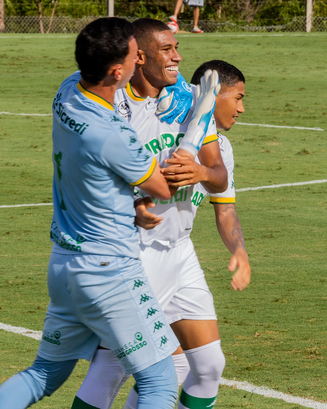 Jogadores do Cuiabá Esporte Clube Sub-20 comemoram em campo após lance positivo, com expressão de alegria e união durante partida em gramado aberto sob sol.