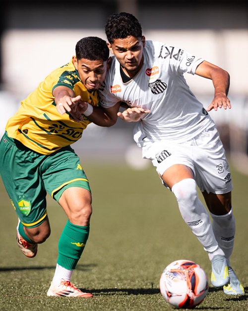 Jogador do Cuiabá Sub-20 disputa bola com atleta do Santos em lance intenso durante partida do Brasileirão Sub-20 no CT Rei Pelé