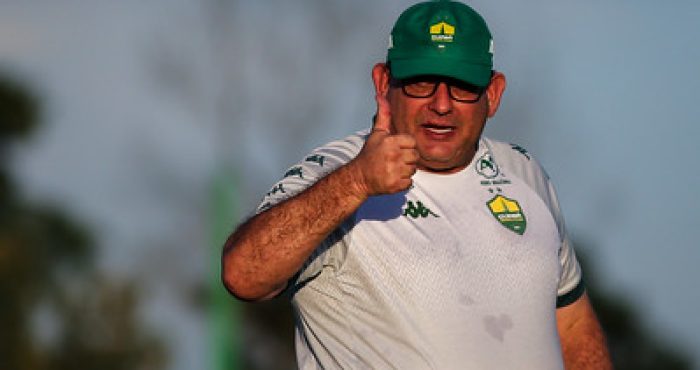 Guto ferreira na beira do campo acenando pra torcida