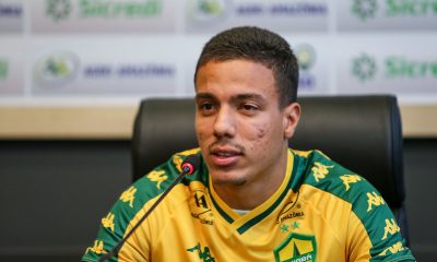 Carlos alberto em coletiva respondendo aos reporteres com a camisa do cuiaba amarela