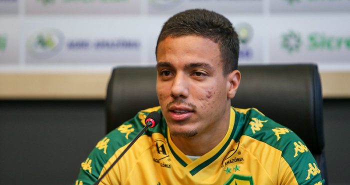 Carlos alberto em coletiva respondendo aos reporteres com a camisa do cuiaba amarela