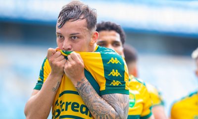 Luiz Felipe beija o escudo do Cuiabá após a partida na Arena Pantanal, celebrando a vitória no Campeonato Mato-grossense diante da torcida.