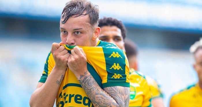 Luiz Felipe beija o escudo do Cuiabá após a partida na Arena Pantanal, celebrando a vitória no Campeonato Mato-grossense diante da torcida.