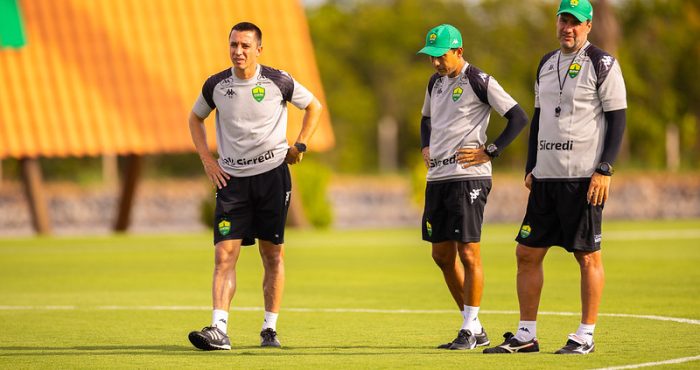 Membros da comissão técnica do Cuiabá observam o treinamento no CT Manoel Dresch, em campo aberto, durante preparação da equipe para a partida na Arena Pantanal.