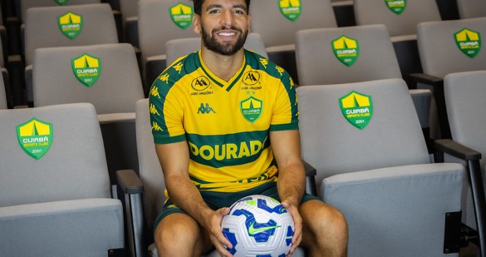 Pepê sentado na Arena Pantanal segurando a bola oficial, durante apresentação como reforço do Cuiabá para a temporada.