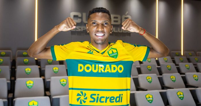 Vinícius Peixoto posa com a camisa do Cuiabá EC no auditório do clube durante sua apresentação oficial como reforço.