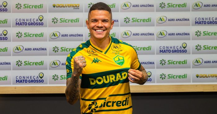 Rodrigo Rodrigues segura a camisa do Cuiabá EC durante sua apresentação oficial como novo atacante do Dourado.