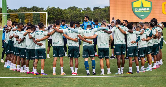 Jogadores do Cuiabá Esporte Clube reunidos em círculo durante treino, demonstrando união e preparação para estreia na Copa Centro-Oeste