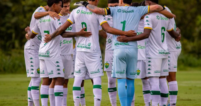 Jogadores do Cuiabá Sub-20 reunidos em roda antes da partida, mostrando união e espírito de equipe no CT Manoel Dresch.