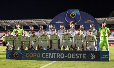 Uma foto clássica da escalação, mostrando os onze titulares e os goleiros. Os goleiros vestem uniformes amarelo-neon/verde de alta visibilidade, enquanto os jogadores de linha usam o tradicional uniforme branco de mandante/visitante com detalhes em verde.