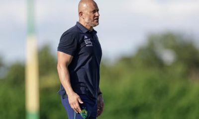 Treinador do Cuiabá durante atividade no campo, usando uniforme azul, com expressão séria enquanto observa o treino da equipe.