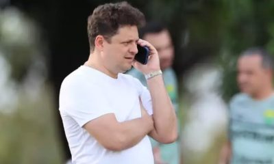 Presidente do Cuiabá aparece falando ao telefone à beira do campo, com expressão séria durante momento de tensão após partida.