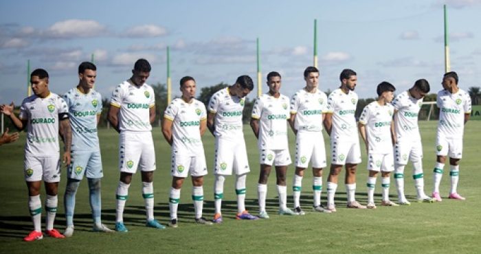 Elenco do Sub-20 do Cuiabá perfilado no gramado antes do início da partida, todos com uniforme branco e postura de concentração.