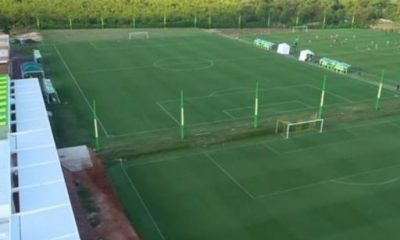 Foto do exterior do novo CT do Cuiabá EC: "Vista do novo Centro de Treinamento do Cuiabá EC, com instalações modernas e campo de treino ao fundo, representando o futuro do time.