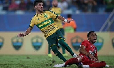 Jogador Pedrinho, do Cuiabá, em ação durante partida contra o Athletico-PR na Arena Pantanal. O atacante disputa a bola após jogada intensa no meio-campo.
