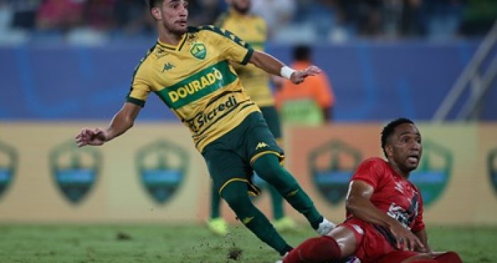 Jogador Pedrinho, do Cuiabá, em ação durante partida contra o Athletico-PR na Arena Pantanal. O atacante disputa a bola após jogada intensa no meio-campo.