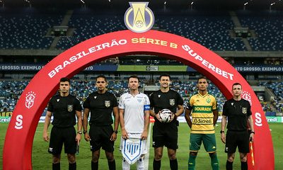 Capitães de Cuiabá e Avaí, ao lado da equipe de arbitragem, posam para a foto oficial sob o arco do Brasileirão Série B Superbet, momentos antes do início da partida na Arena Pantanal.