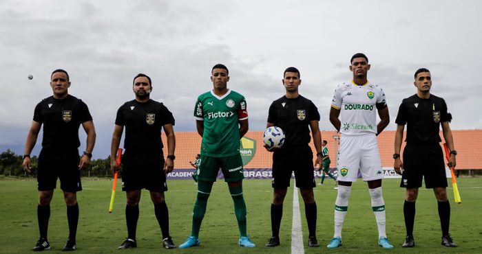 Capitães das equipes Sub-20 de Cuiabá e Palmeiras posam para foto oficial ao lado da equipe de arbitragem, momentos antes do início da partida válida pela 5ª rodada do Campeonato Brasileiro Sub-20, no CT Manoel Dresch, em Cuiabá.