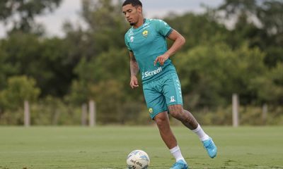 "Jogador Denilson durante treino do Cuiabá, focado na preparação para a semifinal do Campeonato Mato-Grossense. Ele aparece em ação no campo, demonstrando concentração e dedicação."
