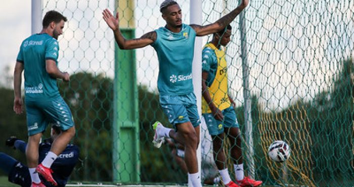 Atacante Derik Lacerda, do Cuiabá, durante treino no CT Manoel Dresch, com os braços erguidos próximo ao gol, em preparação para partida pela Série B.