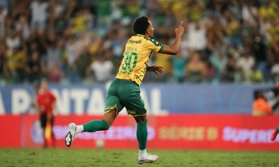 Lucas Mineiro., celebra um gol correndo em direção à torcida, apontando para o alto com o dedo indicador.