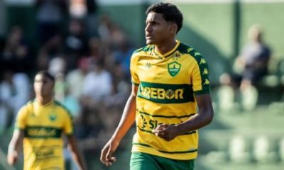 "Widney, atacante do Cuiabá Sub-17, em ação durante partida. O jovem jogador veste o uniforme verde e amarelo do Dourado, demonstrando concentração e habilidade em campo."