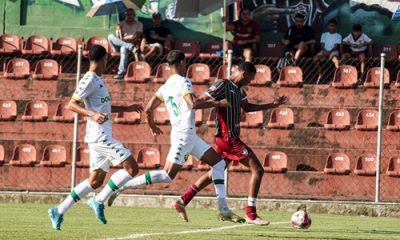 Jogador do Fluminense Sub-20 conduz a bola enquanto é marcado por dois jogadores do Cuiabá durante partida do Brasileirão Sub-20 no Estádio Marcelo Vieira.